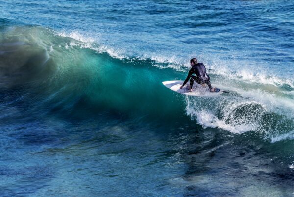 surfer riding a wave surfing in sennen cove